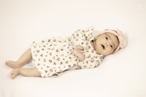 A baby girl dressed in pink is comfortably lying, Lens of Lights Took the photo